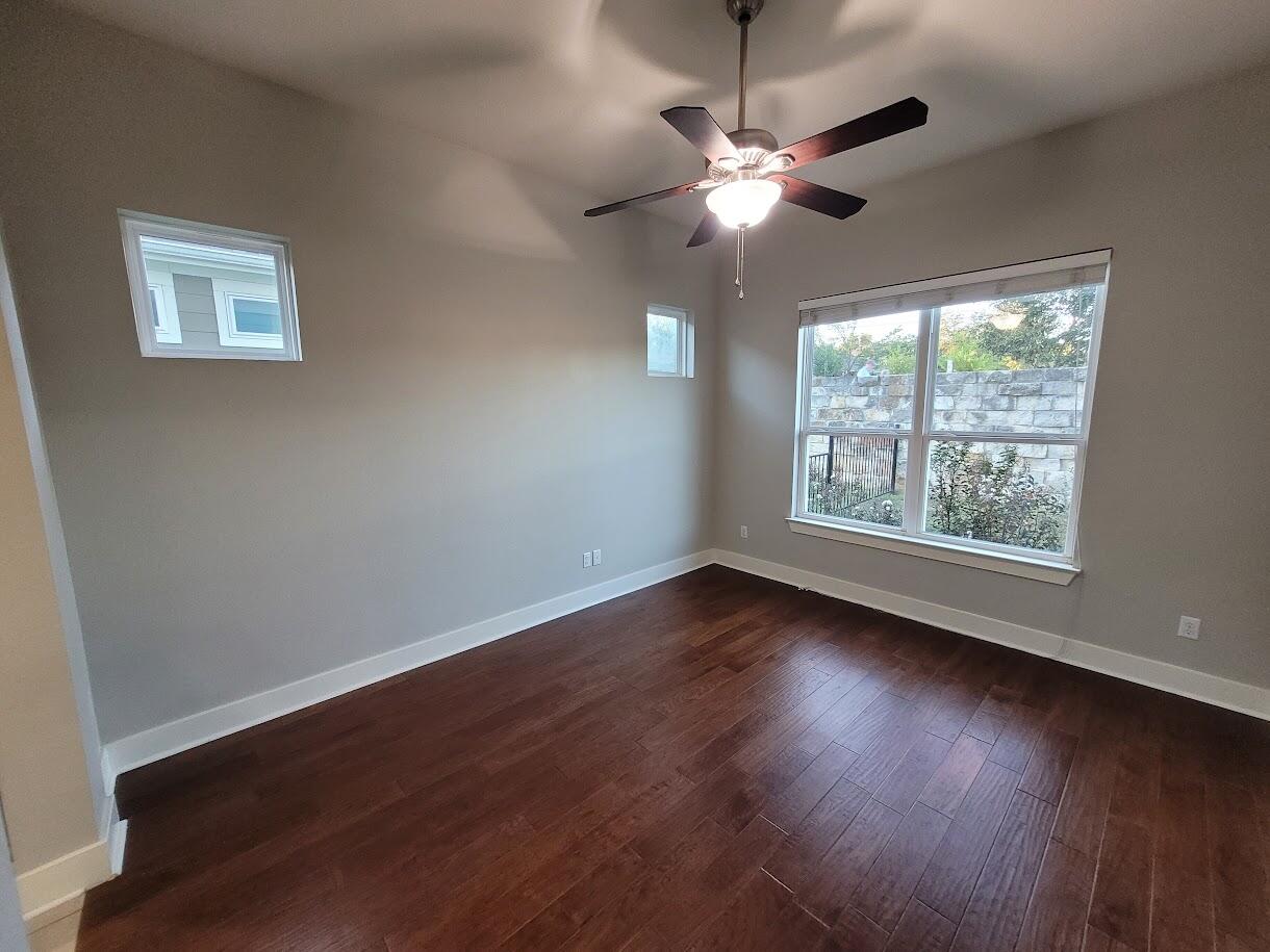 2404 Vintage Stave Road, Unit 102 Austin, TX 78748 - Photo 12 of 39 a view of an empty room with wooden floor and a window