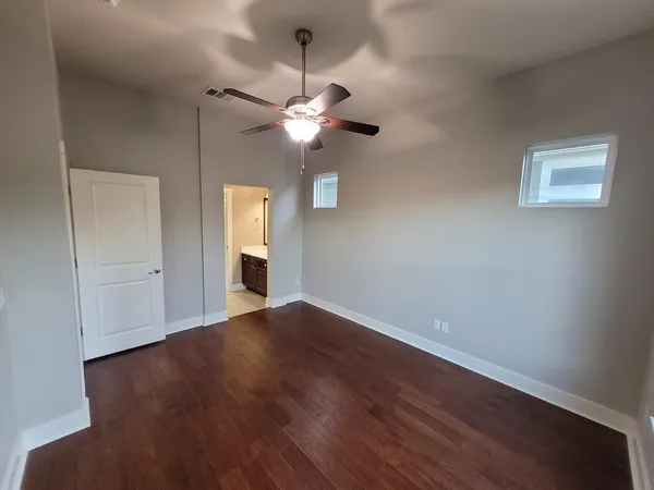 a view of empty room with wooden floor