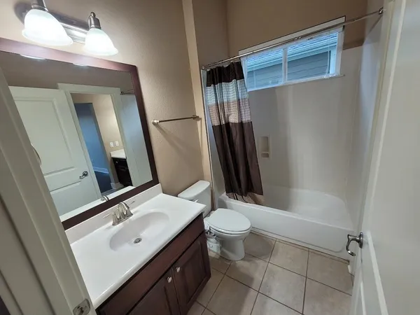 a bathroom with a sink a toilet a mirror and shower