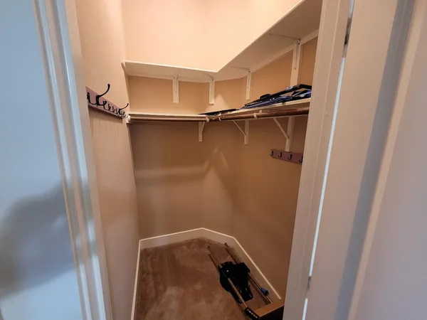 a view of walk in closet with clothes and shoes