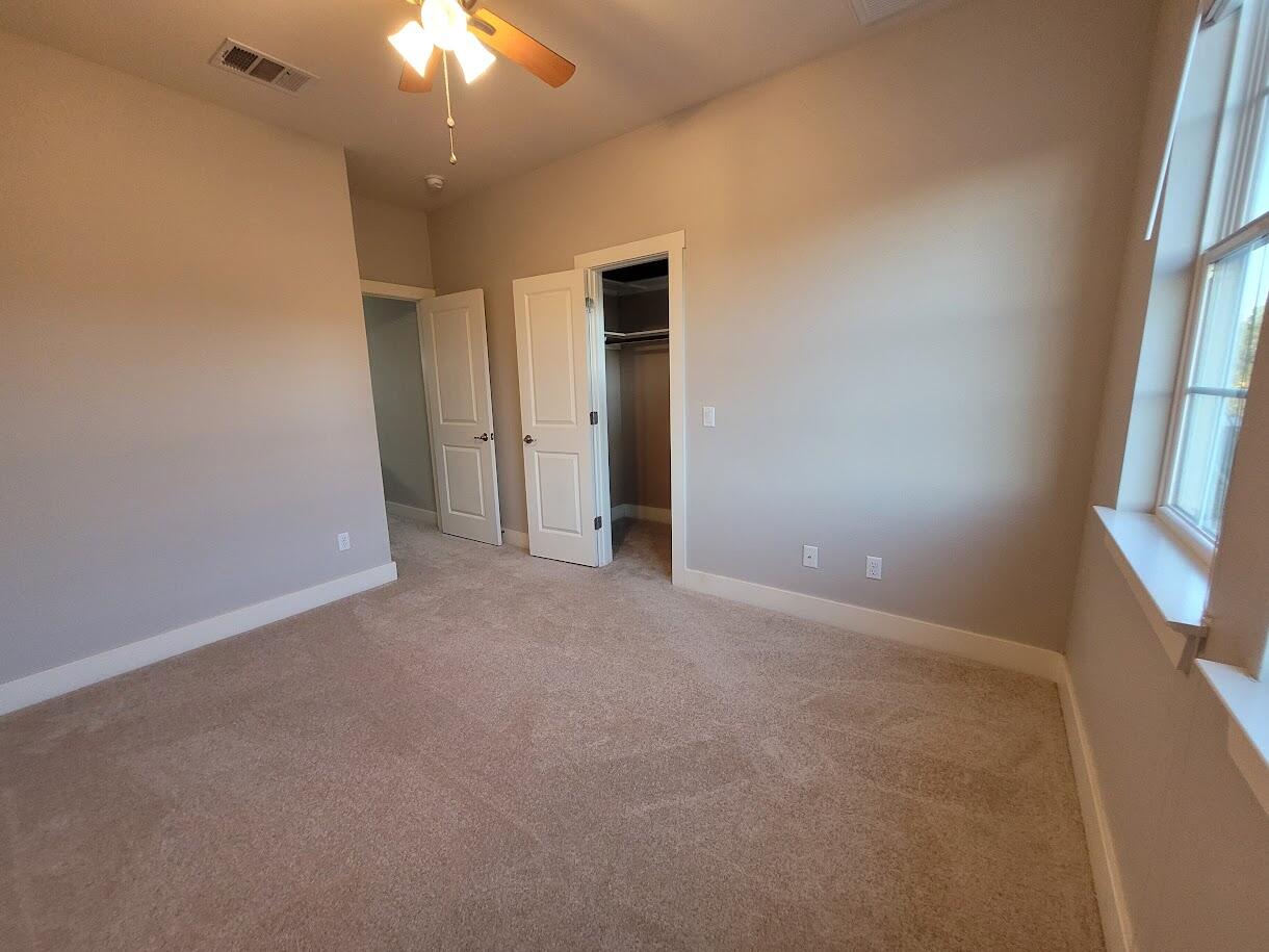 2404 Vintage Stave Road, Unit 102 Austin, TX 78748 - Photo 27 of 39 an empty room with a chandelier fan and windows