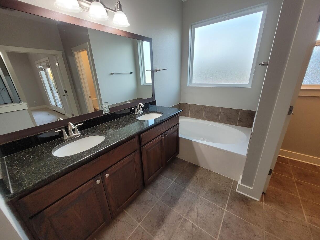2404 Vintage Stave Road, Unit 102 Austin, TX 78748 - Photo 38 of 39 a bathroom with a granite countertop sink and a mirror