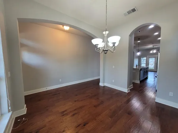 a view of a room with wooden floor and chandelier
