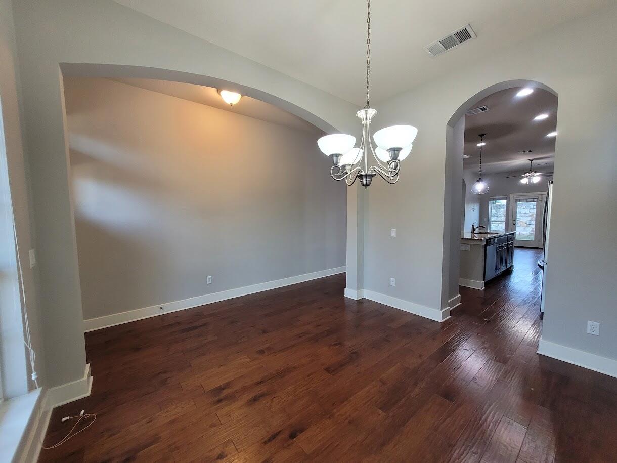 2404 Vintage Stave Road, Unit 102 Austin, TX 78748 - Photo 4 of 39 a view of a room with wooden floor and chandelier