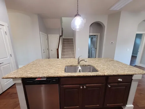 a bathroom with a granite countertop sink a light fixture and a mirror