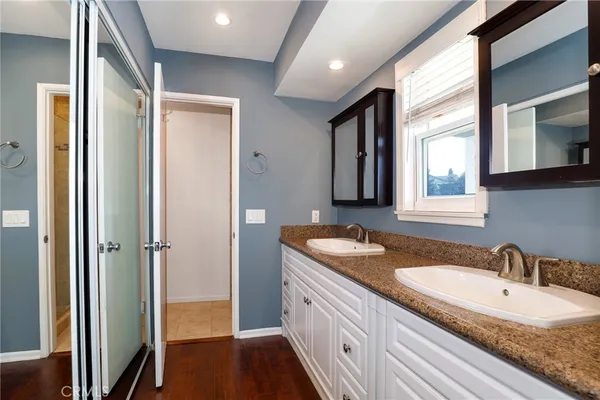a bathroom with a granite countertop sink and a mirror