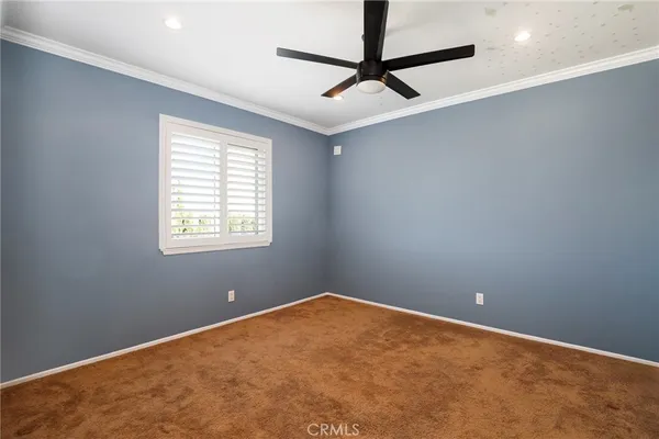 an empty room with a ceiling fan and window