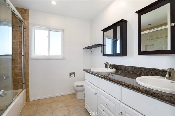 a bathroom with double sink and a mirror