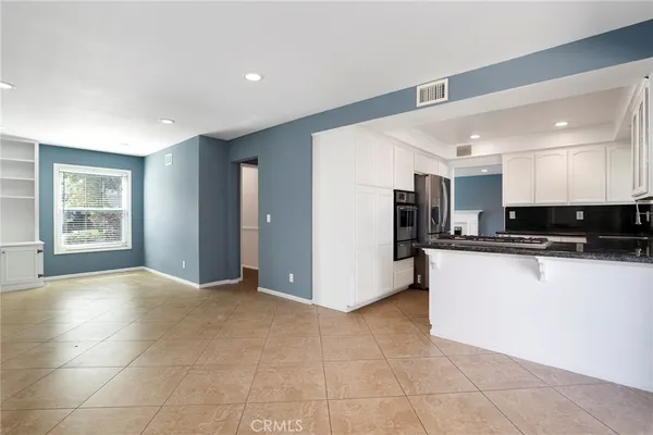 a view of kitchen with stainless steel appliances granite countertop a refrigerator and a stove top oven