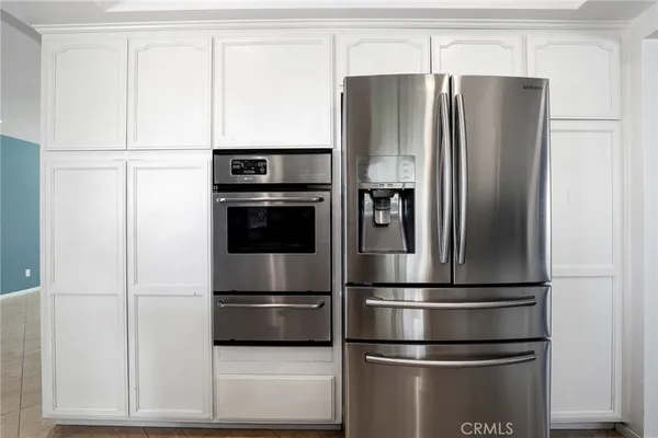 a metallic refrigerator freezer sitting in a kitchen
