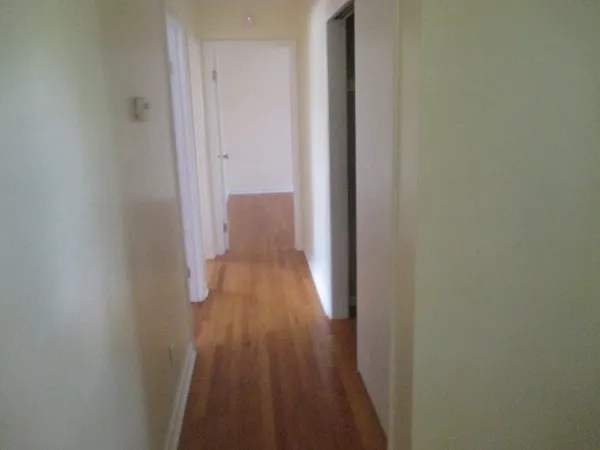 a view of a small space with wooden floor and a window