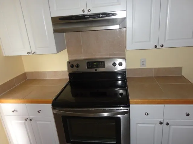 a stove top oven sitting inside of a kitchen