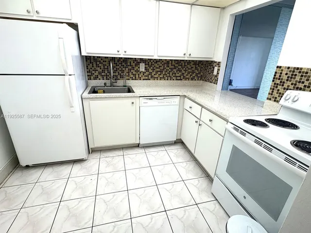 a kitchen with a white stove top oven and white countertops