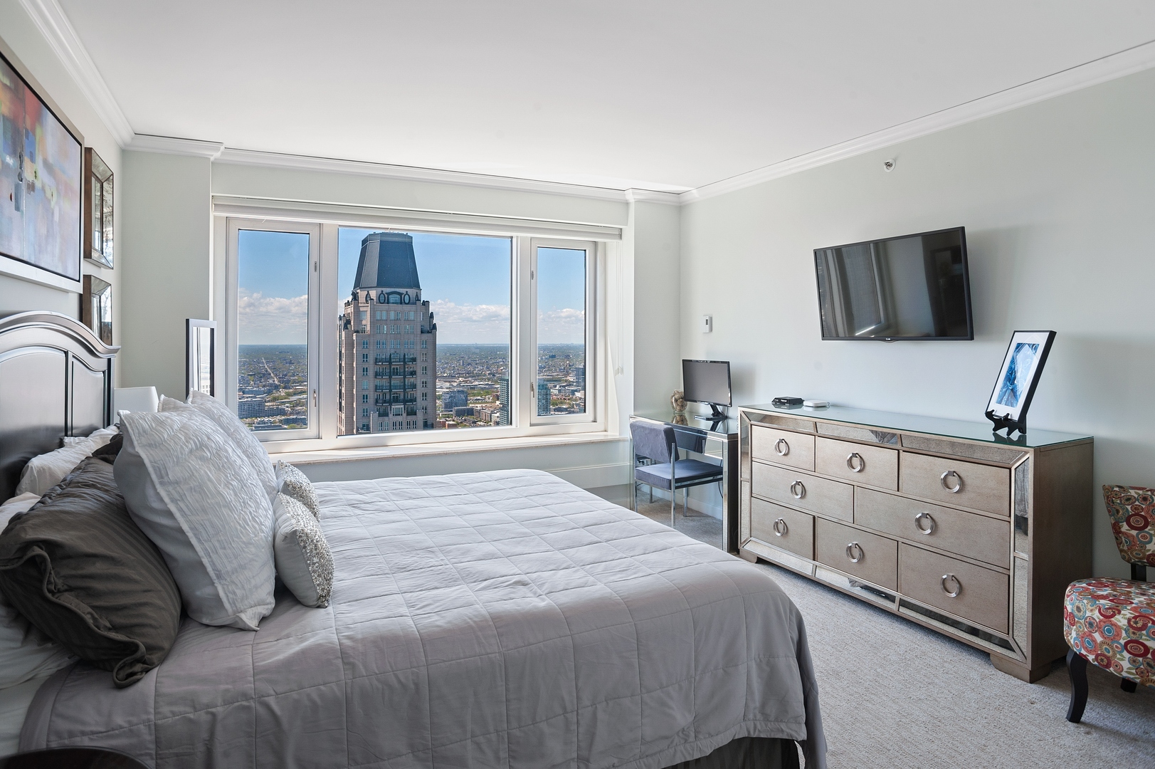 132 East Delaware Place, Unit 4801 Chicago, IL 60611 - Photo 14 of 20 a bedroom with a large bed and a flat tv screen on dresser