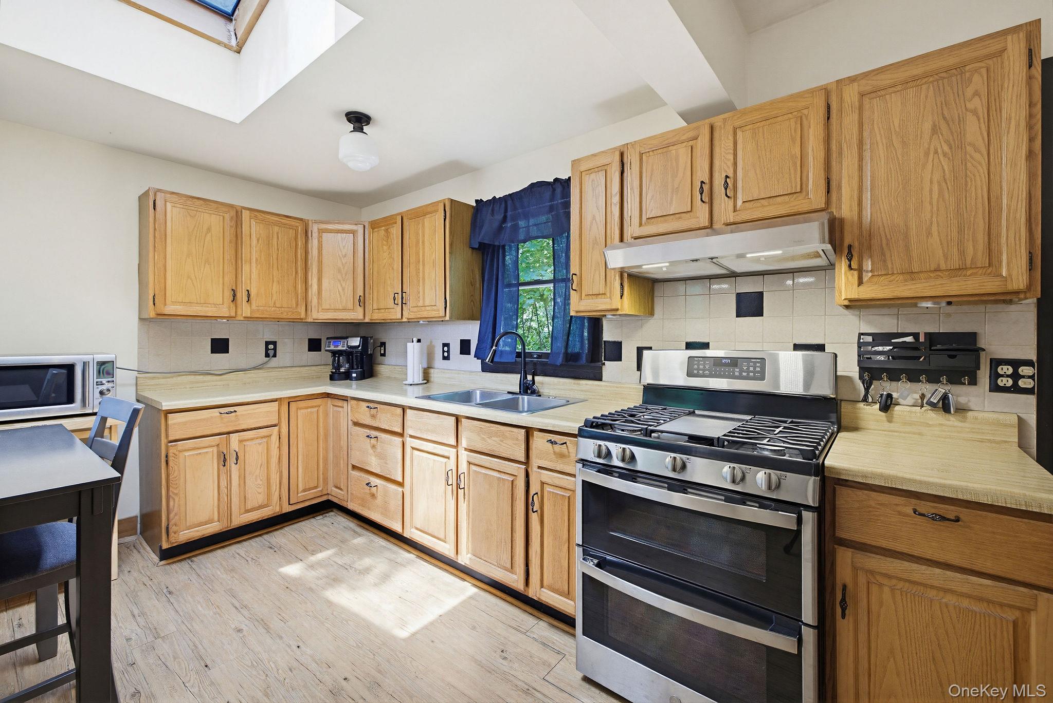 12 Bradhurst Road Carmel, NY 10512 - Photo 13 of 28 a kitchen with stainless steel appliances granite countertop a stove a sink dishwasher and cabinets with wooden floor