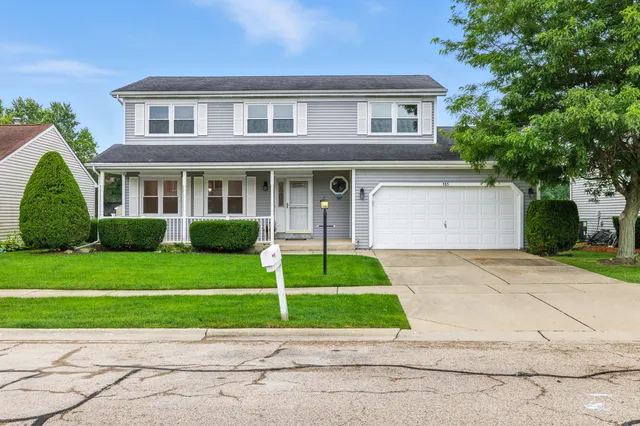 a front view of a house with a garden and plants