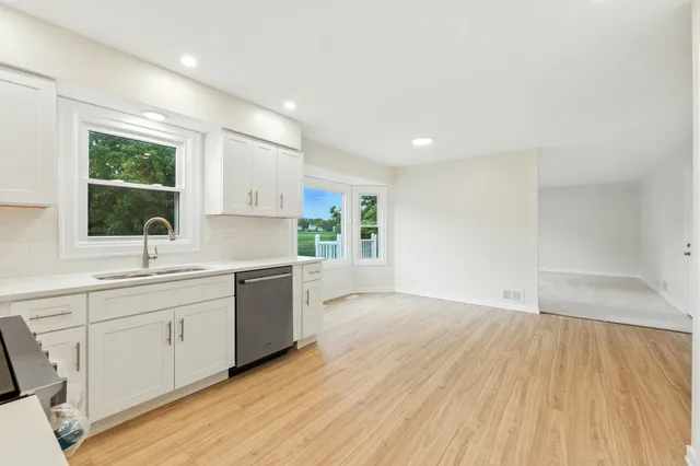 a kitchen with white cabinets and stainless steel appliances