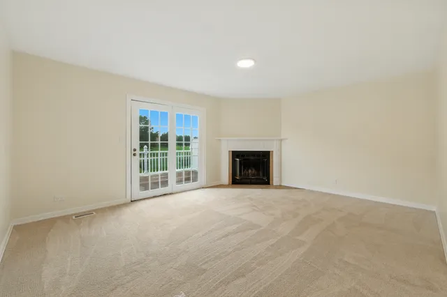a view of an empty room with a fireplace and a window