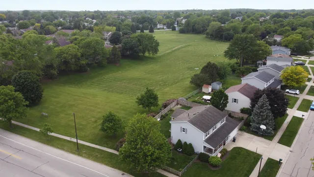 an aerial view of a house with a yard and lake view
