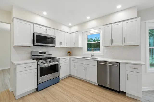 a kitchen with a sink wooden floor and window