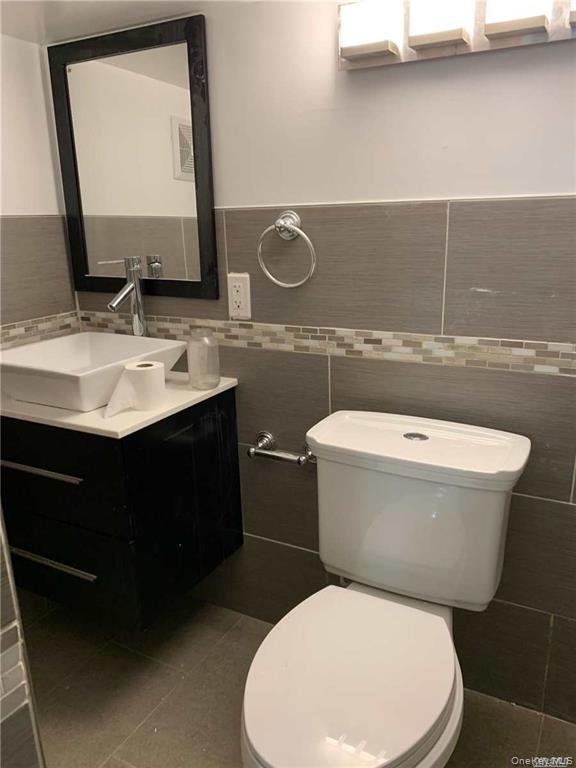 127-22 Hawtree Creek Road Queens, NY 11420 - Photo 5 of 12 a bathroom with a toilet sink and mirror