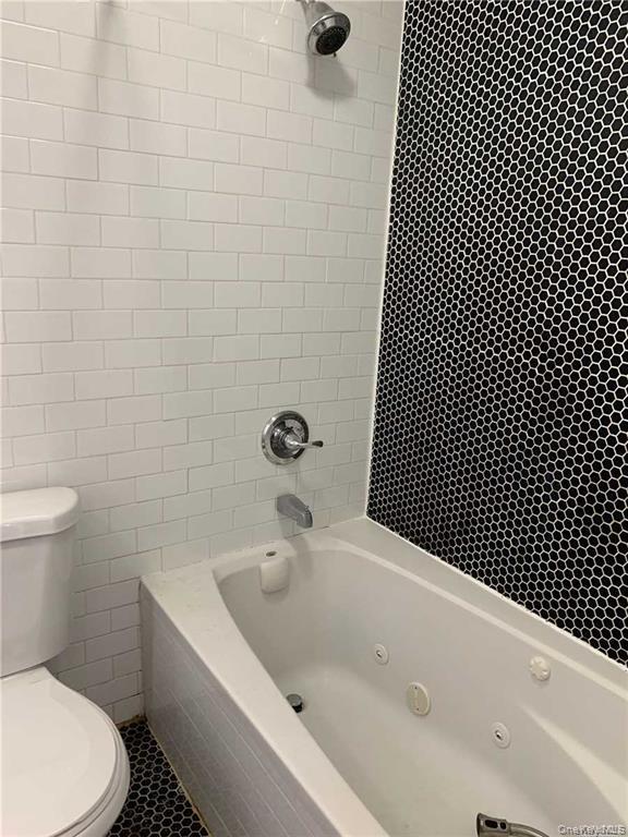 127-22 Hawtree Creek Road Queens, NY 11420 - Photo 9 of 12 a bathroom with a bathtub and toilet