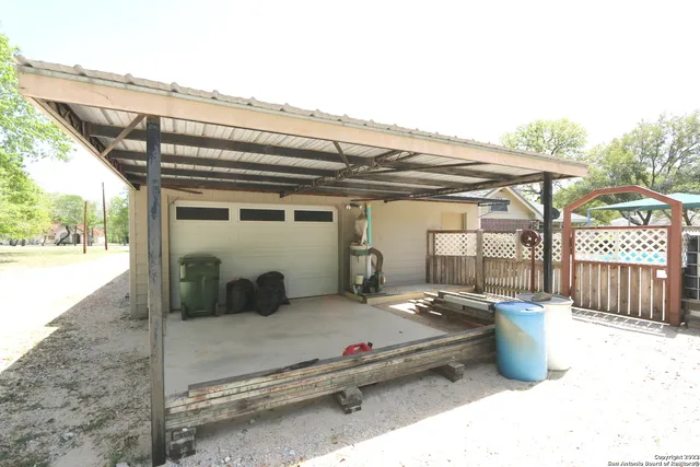a backyard of a house with table and chairs and potted plants
