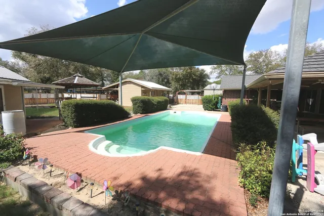 an aerial view of residential house with outdoor space and trees all around