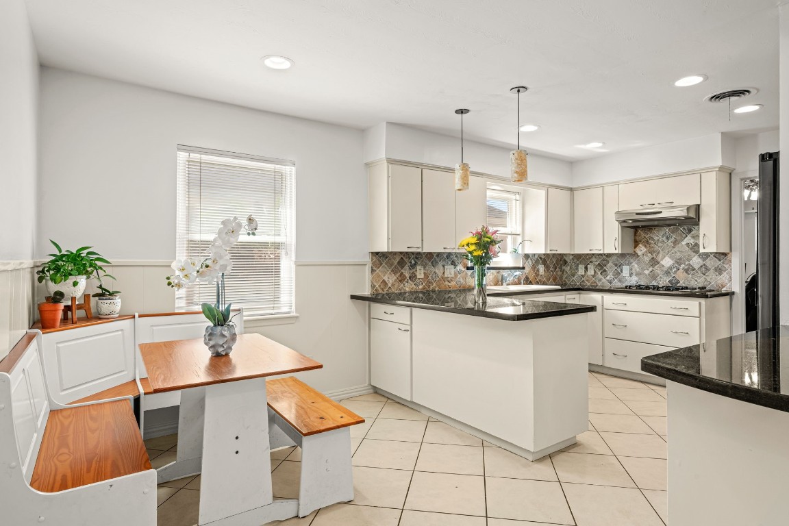 5827 Rutherglenn Drive Houston, TX 77096 - Photo 13 of 30 a kitchen with granite countertop white cabinets a counter and chairs