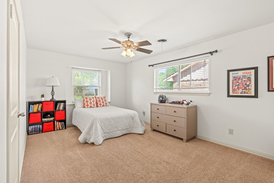 5827 Rutherglenn Drive Houston, TX 77096 - Photo 18 of 30 a spacious bedroom with a bed and a chandelier