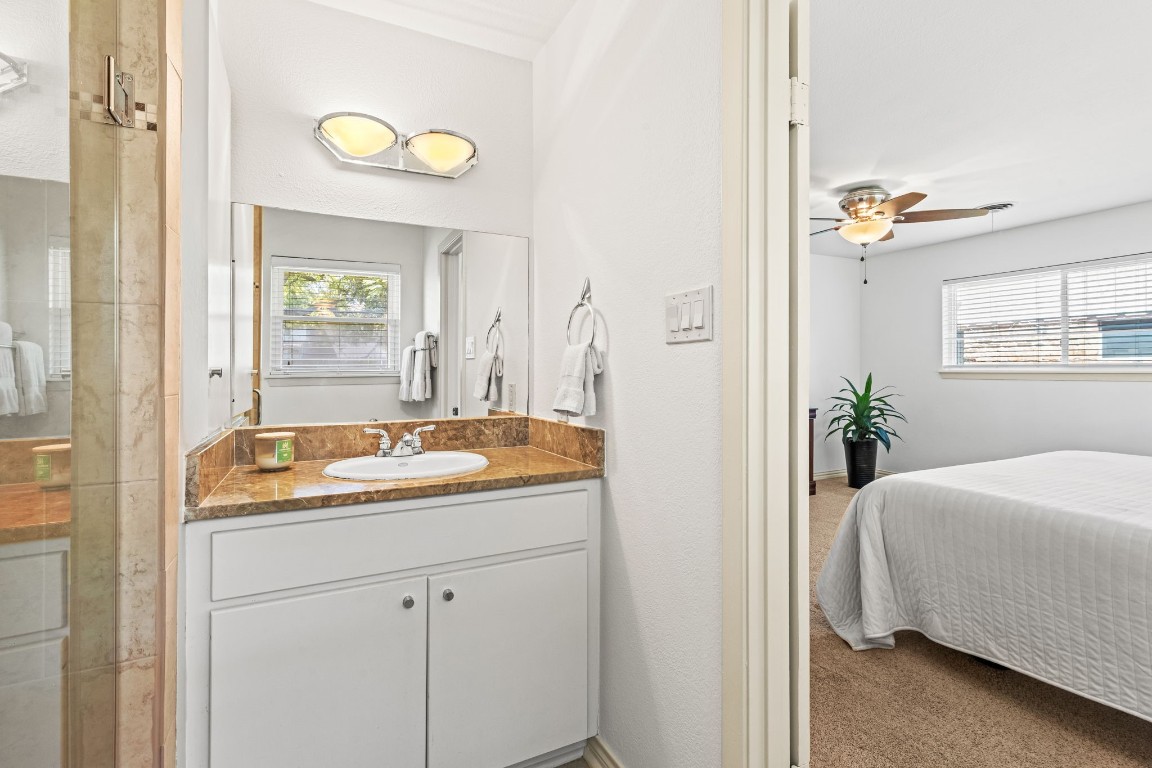 5827 Rutherglenn Drive Houston, TX 77096 - Photo 21 of 30 a en suite bathroom with a granite countertop sink and a mirror