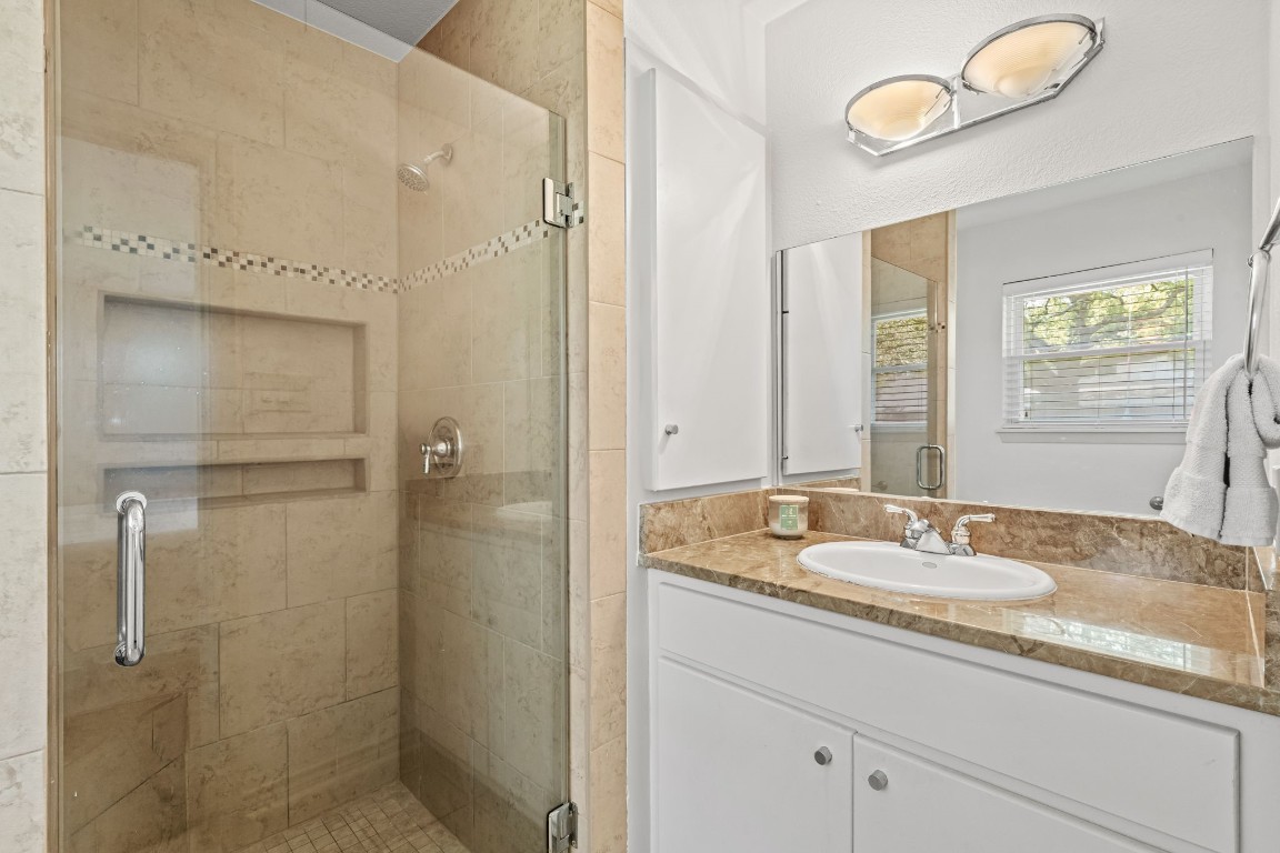 5827 Rutherglenn Drive Houston, TX 77096 - Photo 22 of 30 a bathroom with a granite countertop sink a mirror and shower