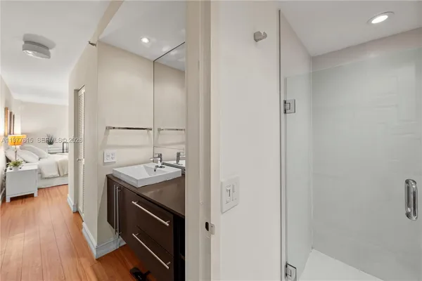 a spacious bathroom with a sink a mirror and a shower