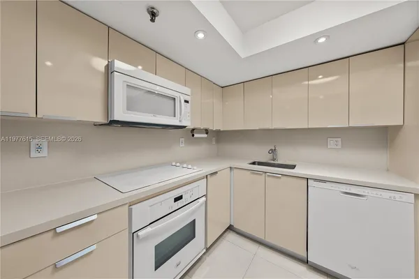 a kitchen with cabinets appliances a sink and a counter top space