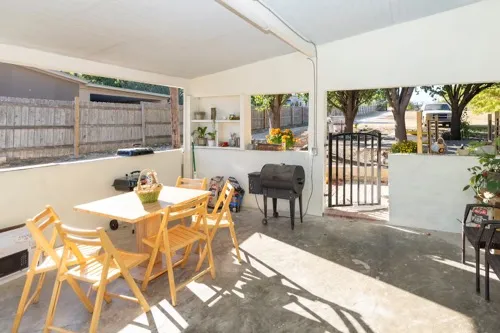 a view of an outdoor dining space with a table and chairs