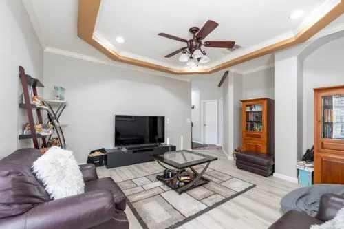 a living room with furniture a ceiling fan and a rug