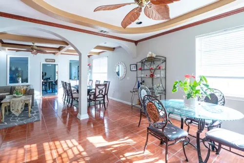 a dining room with furniture potted plants and wooden floor