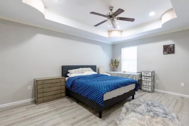 a bedroom with a bed chandelier and a window
