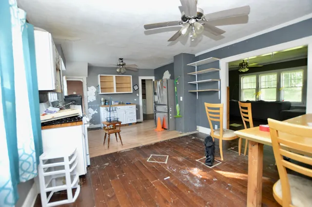 a living room with furniture a dining table and chairs with kitchen view