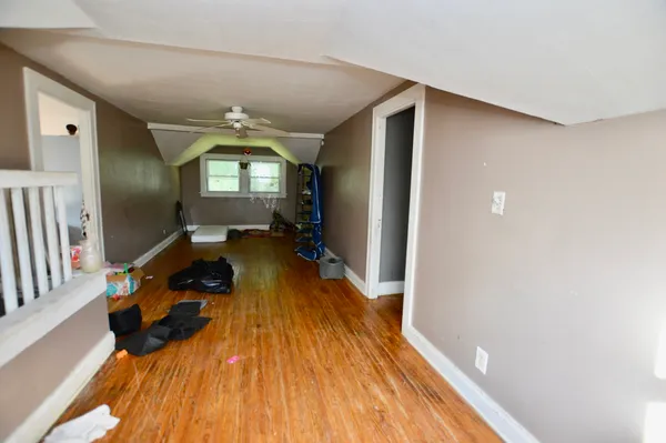 a living room with a bed and a wooden floor
