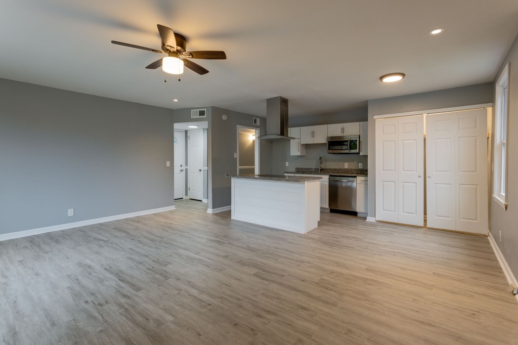 245 Warrior Road Madison, TN 37115 - Photo 9 of 24 an empty room with stainless steel appliances kitchen island hardwood floor and a ceiling fan
