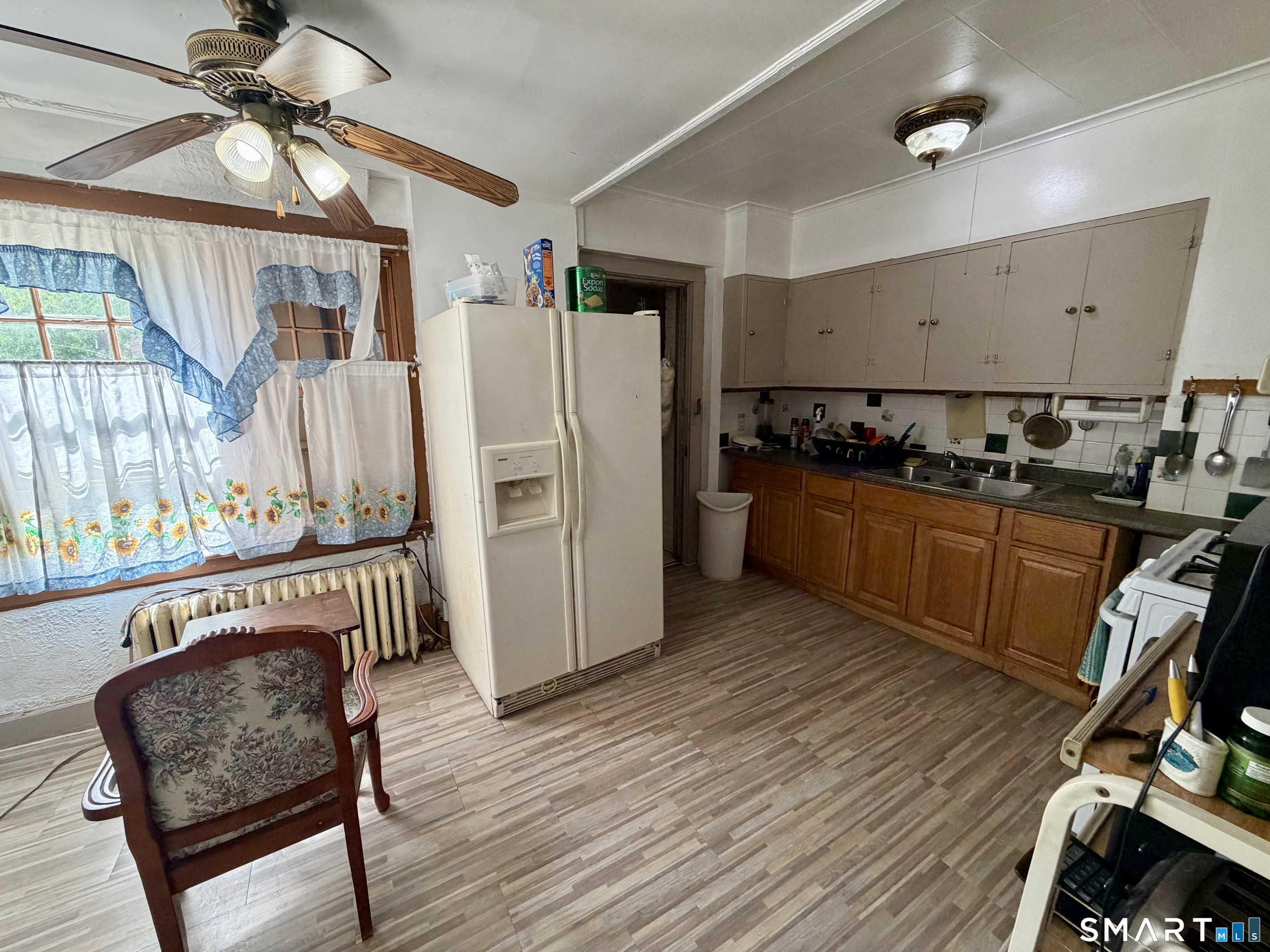 111 Waterman Street Bridgeport, CT 06607 - Photo 4 of 14 a kitchen with stainless steel appliances granite countertop a refrigerator a stove a sink dishwasher and a dining table with wooden floor