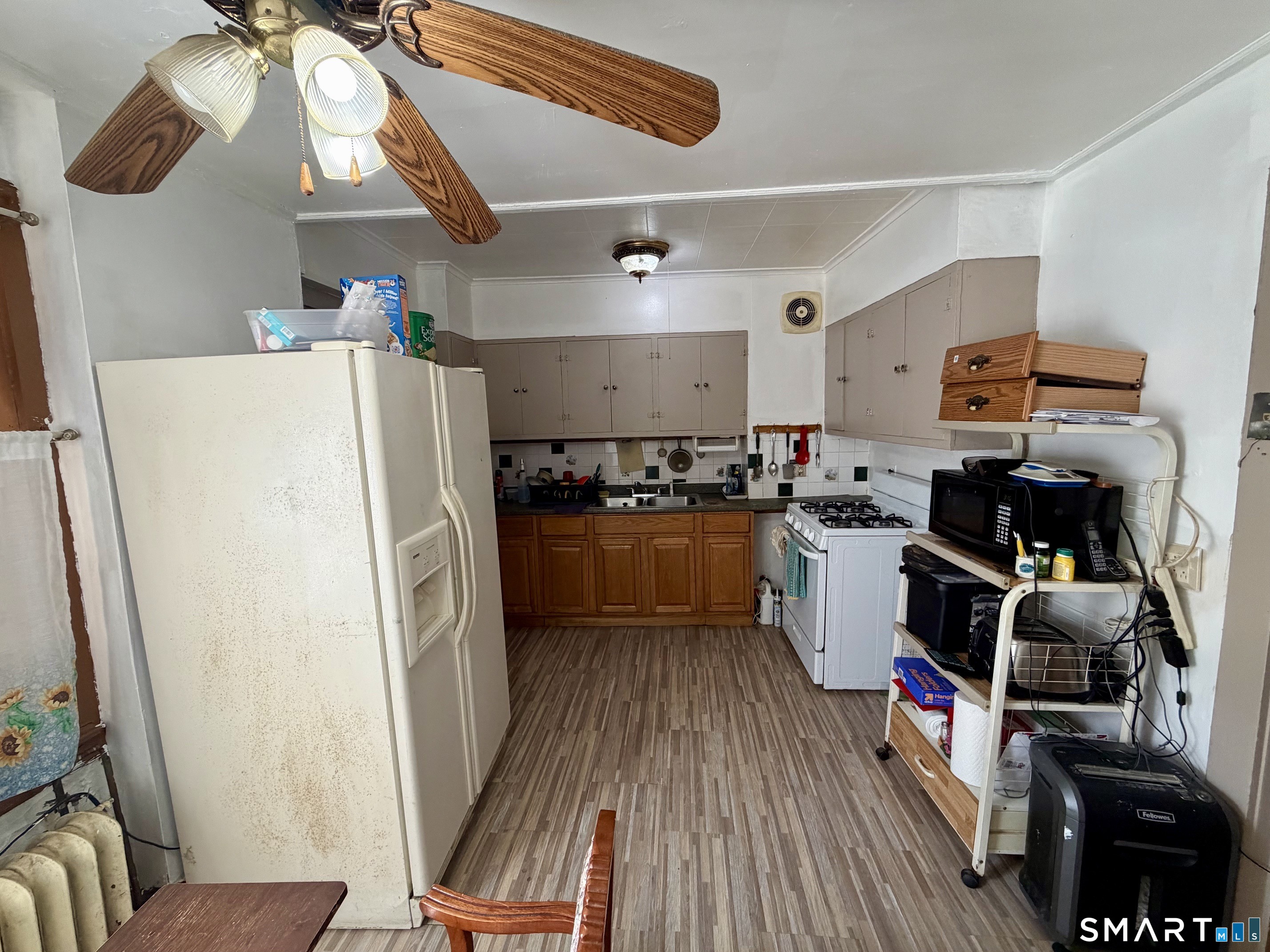111 Waterman Street Bridgeport, CT 06607 - Photo 5 of 14 a kitchen with a refrigerator a stove and wooden floor