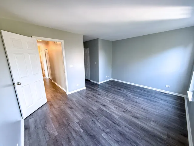 an empty room with wooden floor and entrance
