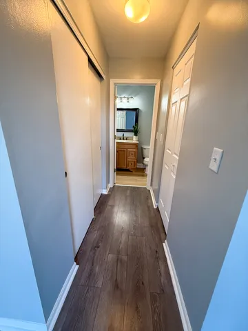 a view of a hallway with wooden floor and staircase