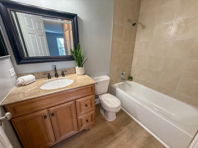 a bathroom with a granite countertop toilet a sink and a bathtub