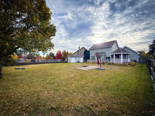 a front view of house with yard and trees in the background