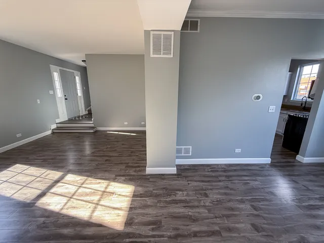 a view of empty room with window and wooden floor