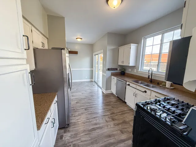 a kitchen with stainless steel appliances granite countertop a refrigerator stove and sink