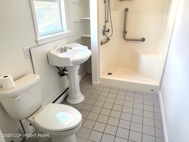 a bathroom with a sink toilet and shower
